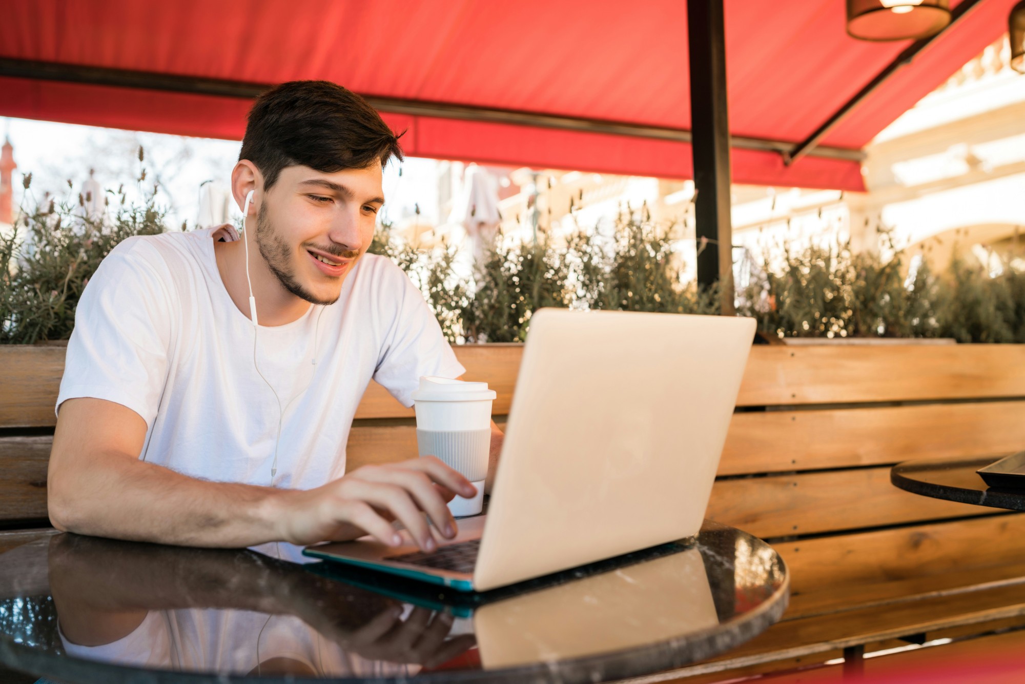 Freelancer managing invoices and projects in Rounded Starter Plan while working remotely at a café.
